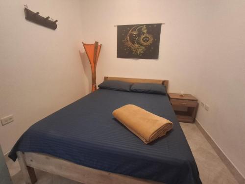 a bedroom with a blue bed with a yellow pillow at Hostal Naty luna - sede alterna in Jardin