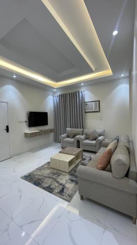 a living room with two couches and a flat screen tv at شقق واڤا in Tabuk