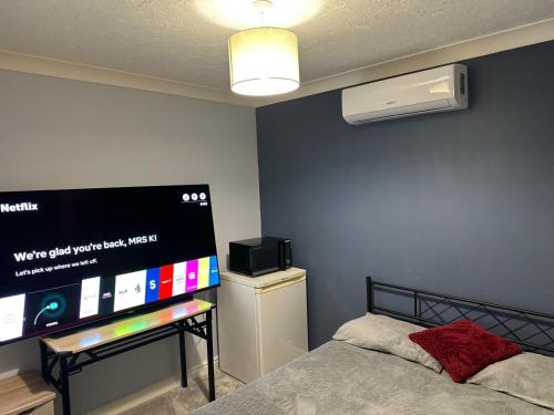 a bedroom with a bed and a flat screen tv at Bnb in Abbeymead