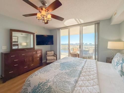 a bedroom with a bed and a dresser with a mirror at Barefoot North Tower - 1203 in Myrtle Beach