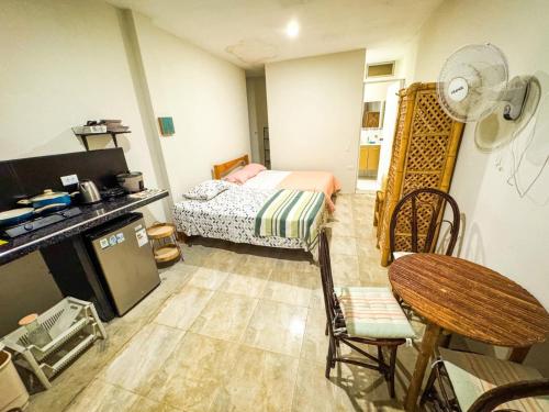 ein kleines Zimmer mit einem Bett und einem Tisch und Stühlen in der Unterkunft Villa Naylamp Loft 3 playa pocitas in Puerto Máncora