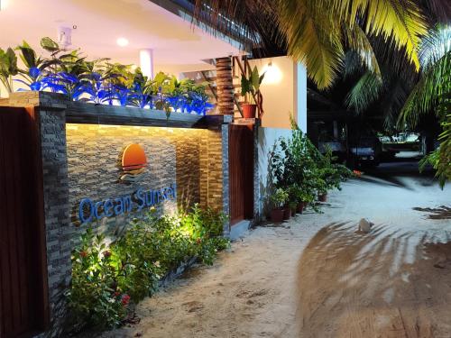 a building with a sign on the side of it at Ocean Sunset in Dhangethi