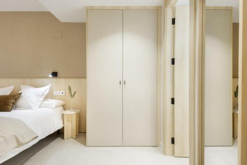 a bedroom with a white bed and a closet at Cima Panticosa by BeValle in Panticosa