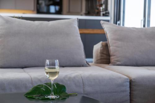 a glass of wine sitting on a table next to a couch at Arion Hotel in Kórinthos