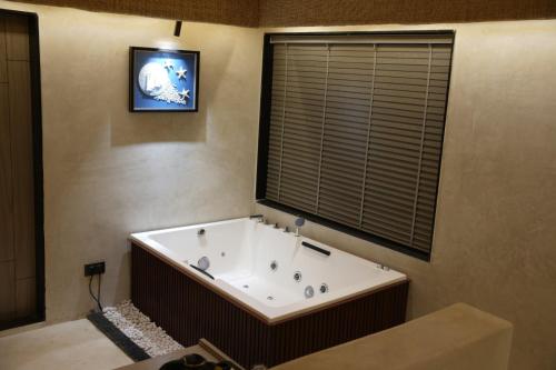 a large bath tub in a room with a window at Wild Forest By Nirvana in Sasan Gir