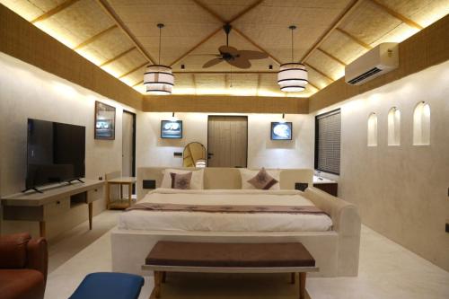 a bedroom with a large bed and a flat screen tv at Wild Forest By Nirvana in Sasan Gir