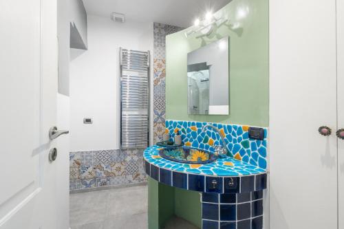 a bathroom with a mosaic sink and a mirror at DrsRome - Colosseum Loft in Rome
