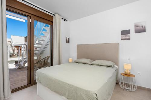 a bedroom with a bed and a balcony at Casa MardeSal in San Pedro del Pinatar