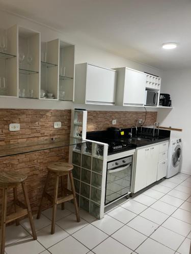 a kitchen with white cabinets and a stove top oven at Residencial Neo 1 in Maceió