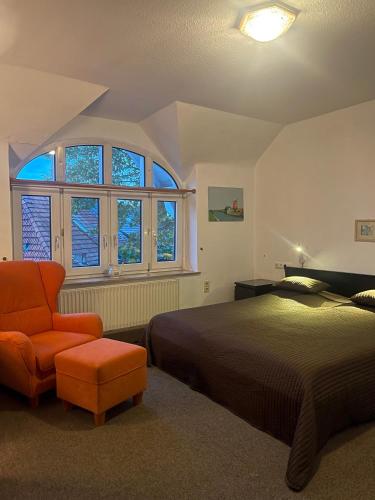 a bedroom with a bed and an orange chair at Parkhotel Essen in Essen