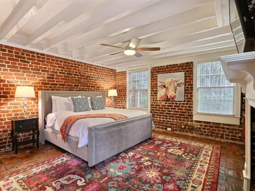 a bedroom with a bed and a brick wall at Mint Julep Estate in Savannah