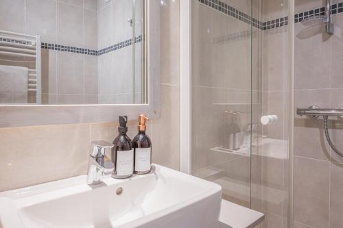a bathroom with two bottles of wine sitting on a sink at Appartement Le Cerf in Les Gets
