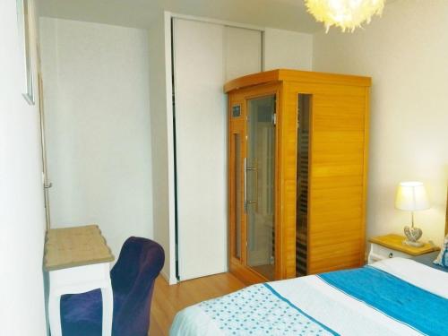 een slaapkamer met een bed en een houten kast bij Apt au calme, 2-3 chambres, Sauna, 2 parkings, wifi in Montévrain
