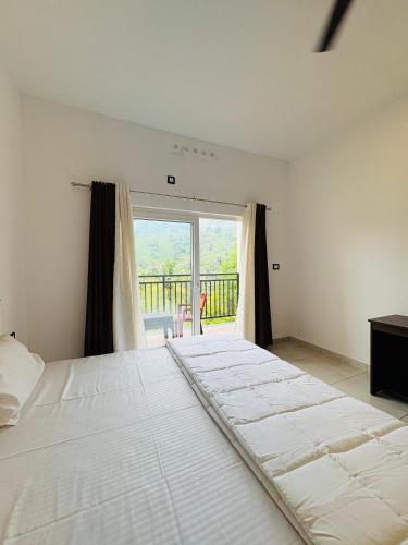 a large white bed in a room with a large window at Ann Villa homestay in Anachal