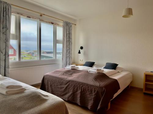 都皮沃古尔弗兰缇德旅馆的一间有两张床和一扇大窗户的卧室