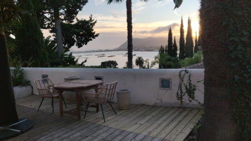 einen Tisch und Stühle auf einer Terrasse mit Blick auf das Wasser in der Unterkunft Villa Les Terrasses Tamaris Les Sablettes in La Seyne-sur-Mer