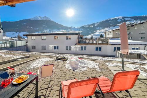a patio with a table and chairs on top of a building at Ferienwohnung Tgesa Sulai in Savognin
