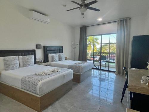 une chambre avec deux lits et une grande fenêtre dans l'établissement Alux, à Bacalar