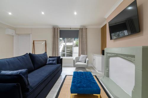 a living room with a blue couch and a tv at Stylish Flat near Regent's Park in London