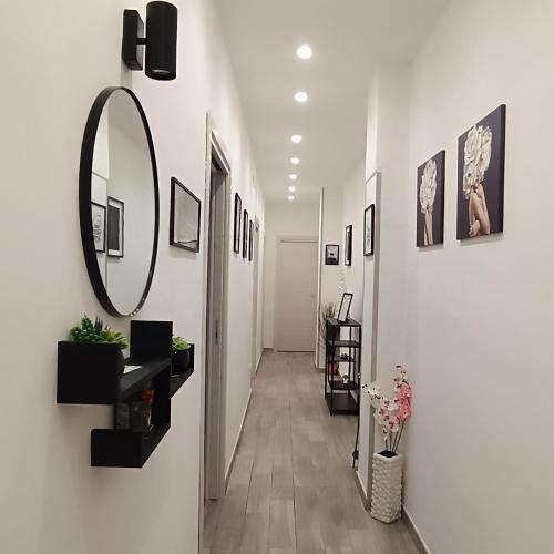 een hal met een spiegel aan een muur met foto's bij Sogni di Stelle in Salerno