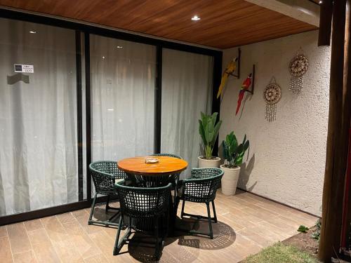 a patio with a table and chairs on a balcony at Naay Villas - Flat Beira mar exclusivo in Pôrto de Pedras