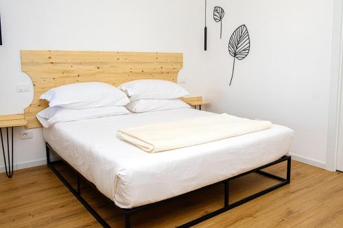 a bed with white sheets and pillows in a room at Dolcevita guest house in Torreano