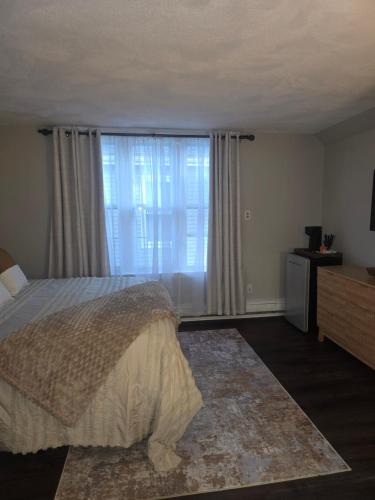 a bedroom with a bed and a large window at Cozy Room in Revere near Beachmont Blue Line Station in Boston