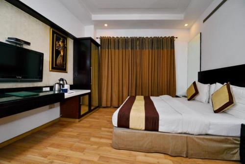 a hotel room with a bed and a flat screen tv at Hotel P&G Group - Prime Location Walking the all Best Market New Delhi in New Delhi