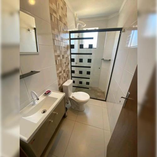 ein weißes Badezimmer mit Toilette und Waschbecken in der Unterkunft Hotel Tejas Verdes in Villa Gesell