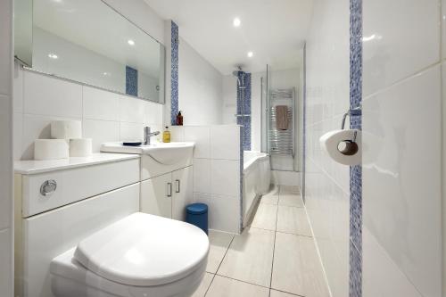 a white bathroom with a toilet and a sink at Stylish Flat near Regent's Park in London