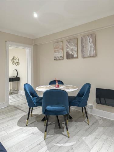 a dining room with a table and blue chairs at Stylish Flat near Regent's Park in London