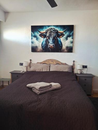 a bed with a picture of a bull on the wall at Casa Piszi in Torrevieja