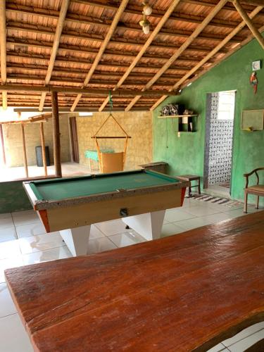 a pool table in a room with green walls at Chácara em Carmo do Cajuru in Carmo do Cajuru