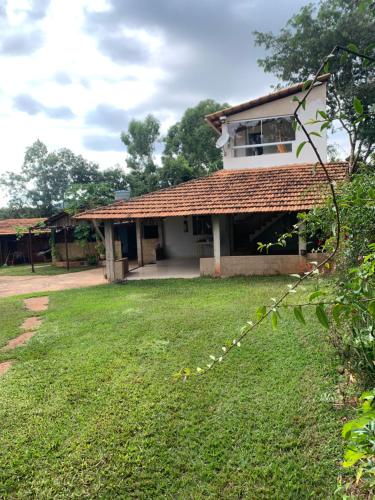 a house with a grass yard in front of it at Chácara em Carmo do Cajuru in Carmo do Cajuru