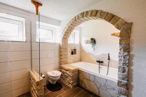 a bathroom with a bath tub and a toilet at Ferienhaus Lärchenblick in Kurort Altenberg