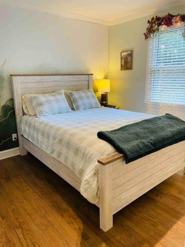 a bedroom with a large bed with a green blanket at Downtown - 2 bed, 1 bath - KC in Raleigh