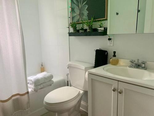 a white bathroom with a toilet and a sink at Downtown - 2 bed, 1 bath - KC in Raleigh