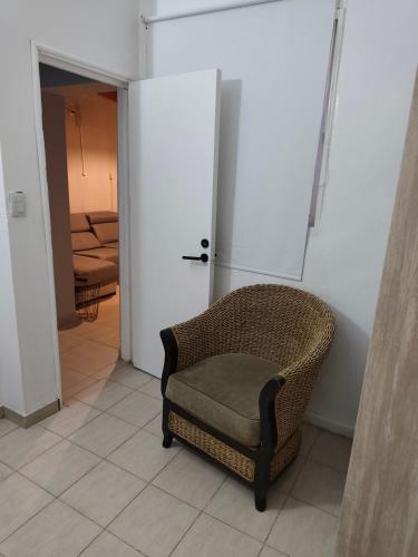 ein Korbstuhl auf einem Fliesenboden in einem Raum in der Unterkunft Departamentos Negretti in Junín