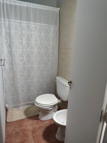 ein Badezimmer mit Toilette und Duschvorhang in der Unterkunft Departamentos Negretti in Junín