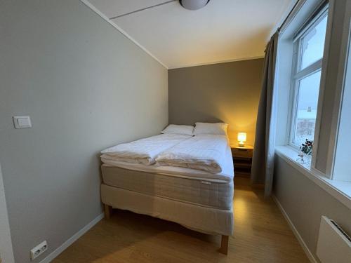 a small bed in a room with a window at Modern 2 bedroom apartment in the heart of Tromsø in Tromsø