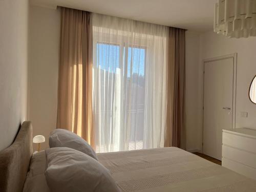 une chambre avec un lit et une grande fenêtre dans l'établissement White Noise Como, à Côme