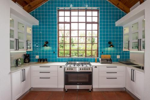 a kitchen with white cabinets and a stove top oven at Golf Estate Vacation Property - Poseidon's Knoll in White River