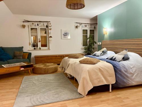 a bedroom with two beds and a couch at Gîte le Nid in Uffholtz