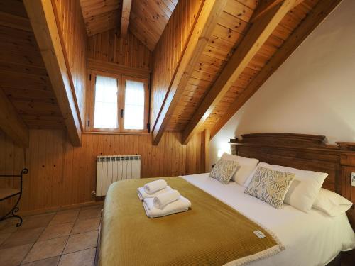 Un dormitorio con una cama con dos toallas encima. en Apartamentos Fogaron, en Saravillo