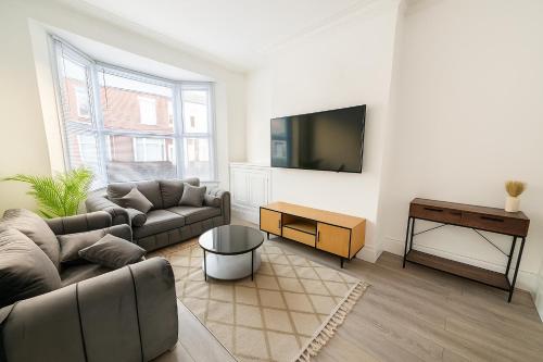 a living room with a couch and a flat screen tv at Quiet & Modern 3-Bed Home Near Beach & Marina in Hartlepool