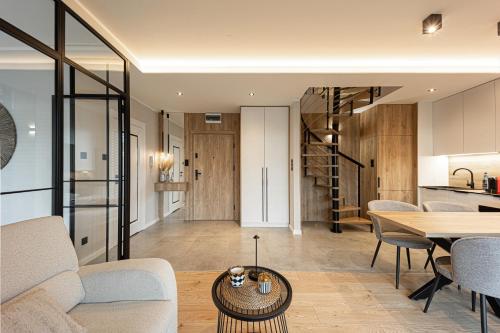 un soggiorno con un divano e un tavolo di Marina Ostróda III - widok na jezioro, podziemny garaż, winda, klimatyzacja, wanna i prysznic, 2 łazienki, lux a Ostróda