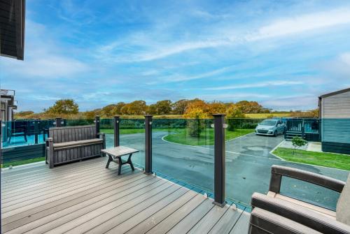 a deck with a bench and a table at Harbour Retreat at Cormorant View - Luxury Lodge with Hot Tub - Hayling Island - Mill Rythe Holiday Village in North Hayling