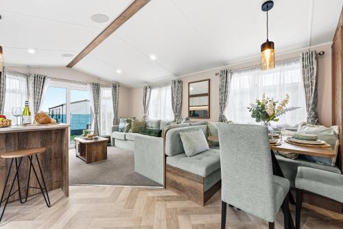 a living room with a table and a couch at Harbour Retreat at Cormorant View - Luxury Lodge with Hot Tub - Hayling Island - Mill Rythe Holiday Village in North Hayling