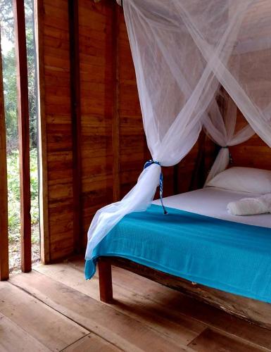 a bedroom with a bed with a mosquito net at Manglar Eco Resort in La Barra