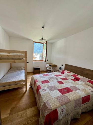 a bedroom with two bunk beds and a window at Appartamento Conca Epolo in Schilpario